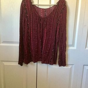 This blouse is burgundy with designs mixed through